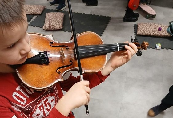 Enfant jouant du violon, concentré, pendant un stage musique enfant pâques et sessions d’éveil musical.