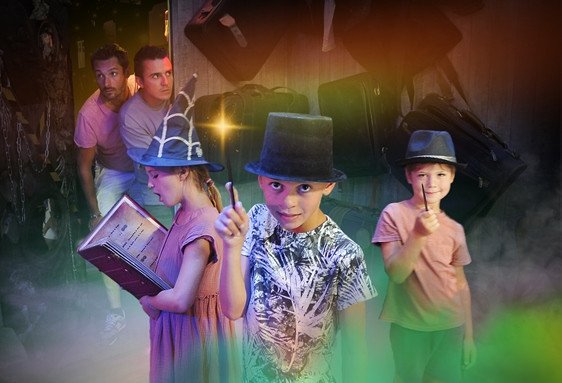 Des enfants en costumes et chapeaux ressemblant à des personnages d’escape game, l’un tient une baguette et pointe vers