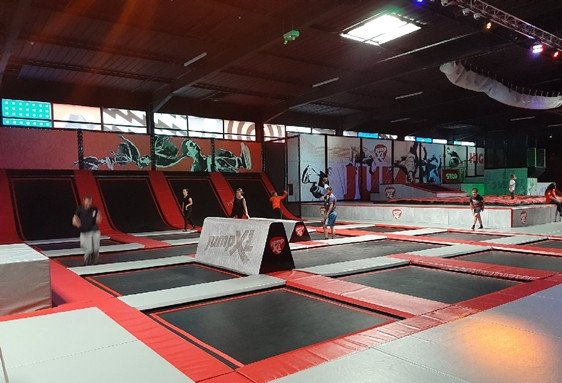 Parc couvert intérieur avec trampolines et modules pour enfants, ambiance sportive et éveil moteur. Parc anniversaire enfant Île de France.